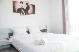ein Schlafzimmer mit einem weißen Bett mit zwei Handtüchern darauf in der Unterkunft Riverside-Modern apartment-ARED in Oradea