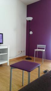 salon z fioletową ścianą, stołem i lampką w obiekcie Apartamento Gallego VUT-PO-02510 w mieście Sanxenxo