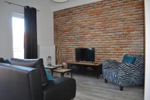 a living room with two chairs and a brick wall at Walnusshof Bad Salzungen in Bad Salzungen