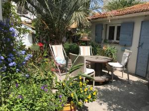 a patio with a table and chairs and flowers at Cabanon de Camille in Saintes-Maries-de-la-Mer