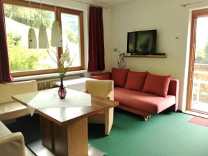 ein Wohnzimmer mit einem Sofa und einem Tisch in der Unterkunft Sonnenhaus Sander in Schruns-Tschagguns
