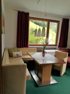 ein Wohnzimmer mit einem Sofa, einem Tisch und einem Fenster in der Unterkunft Sonnenhaus Sander in Schruns-Tschagguns