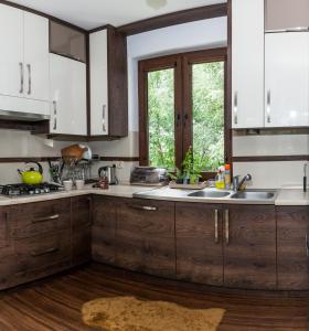 uma cozinha com armários de madeira e um lavatório em Przystan Kurpiowska em Turośl
