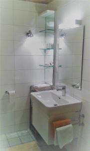 Baño blanco con lavabo y espejo en Sonnenhaus Sander, en Schruns