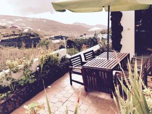 a table and chairs under an umbrella on a patio at Casa Rural Miposa in Mocanal
