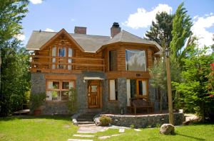 a log home with a porch and a door at Cabanas Luces el Bosque in Mar de las Pampas