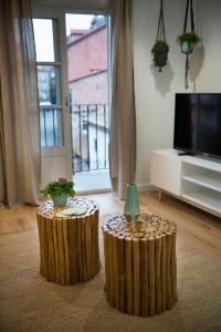 2 taburetes de madera en una sala de estar con TV en Apartamento Luscofusco en Ourense