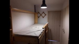 レ・デュー・アルプにあるRésidence le Plein Sudのベッドルーム1室(ライト付きの木製ベッド1台付)