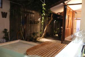 una mesa con un banco de madera en una habitación en Trava House, en Yogyakarta