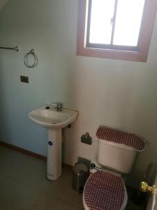 a bathroom with a sink and a toilet and a window at Casa Rukalma Estación in Villarrica +14 photos