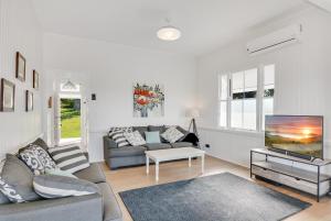 a living room with a couch and a tv at Cloud Hill in Maleny