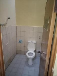 y baño pequeño con aseo y ducha. en Syifa Homestay en Gili Trawangan