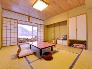 een kamer met een tafel en stoelen in een kamer bij Shikaribetsu Kohan Onsen Hotel Fusui in Shikaoi