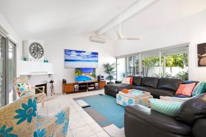 a living room with a couch and a tv at 26 Witta Circle, Noosa Heads in Noosa Heads