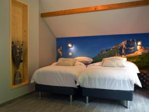 2 Betten in einem Zimmer mit Wandgemälde in der Unterkunft Le MOULIN des CHARTREUX - 1733 in Saint-Pierre-dʼEntremont