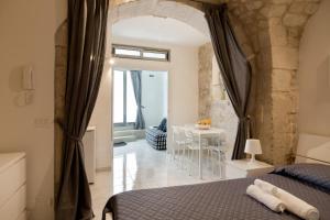 een slaapkamer met een bed en een tafel bij Dammuso delle Gioie in Scicli
