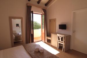 a bedroom with a bed and a door to a balcony at Monte San Giovanni-Nebrodi Rooms in San Marco dʼAlunzio