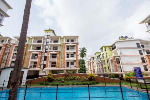 a row of apartment buildings with a tennis court at 2BHK -Balcony & Pool View -Monarch Palms, Cadolim in Candolim