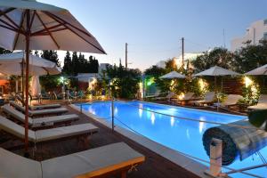 a swimming pool with lounge chairs and umbrellas at Villa Katerina in Parikia