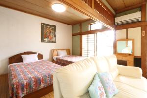 uma sala de estar com um sofá e uma cama em Hitoyoshi Morinohall Ladies in - Female Only em Hitoyoshi
