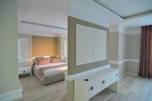 a bedroom with a bed and a large mirror at Te Stela Resort & SPA in Tirana