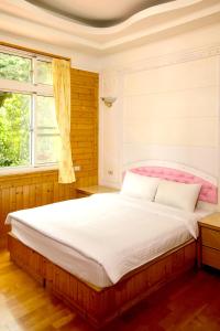 ein Schlafzimmer mit einem großen Bett und einem Fenster in der Unterkunft Yi Xin Homestay in Nanzhuang