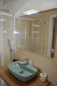 a bathroom with a green sink and a mirror at B&B Jolie center in Pescara