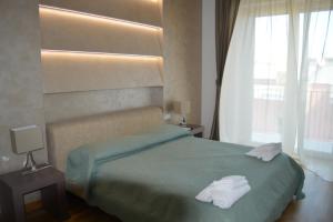 een slaapkamer met een groen bed en handdoeken bij B&B Jolie center in Pescara