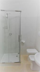 La salle de bains est pourvue d'une douche en verre et de toilettes. dans l'établissement Incontro Montoro Guest House & Restaurant, à Montoro Inferiore