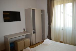 a bedroom with a bed and a tv and a window at B&B Jolie center in Pescara