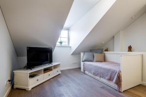 a bedroom with a bed and a flat screen tv at Angel House Vilnius 38 in Vilnius