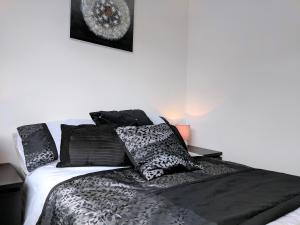 a bed with black and white sheets and pillows at Whiteley Street in Manchester