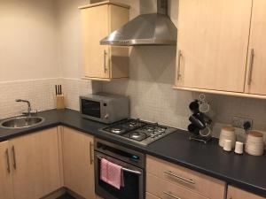 a kitchen with a stove top oven next to a sink at Apartment 2 Bed West End in Glasgow