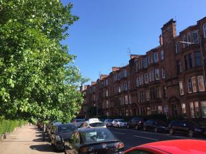 une rue avec des voitures garées sur le côté de la route dans l'établissement Apartment 2 Bed West End, à Glasgow