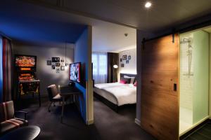 a hotel room with a bed and a desk at pentahotel Paris Charles de Gaulle in Roissy-en-France