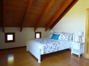1 dormitorio con cama blanca y techo de madera en Magnolia Cottage, en Cooroy