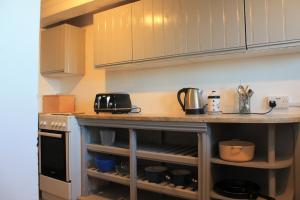 una cucina con bancone e alcuni elettrodomestici di Snowdrop Cottage a Gloucester