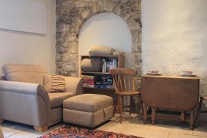 un soggiorno con sedia e tavolo di Snowdrop Cottage a Gloucester