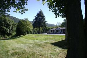 een grasveld met een huis en een boom bij Appalachian Motel in Vernon