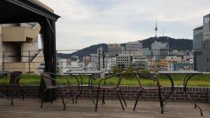 un grupo de mesas y sillas en un balcón en Grid Inn Hotel, en Seúl