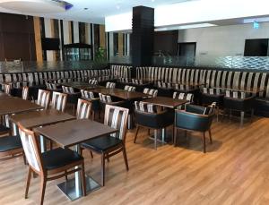 a dining room with wooden tables and chairs at Ramee Rose Hotel in Dubai
