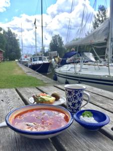 a table with a bowl of soup and a cup of coffee at Hajstorp Slusscafé & Vandrarhem in Töreboda