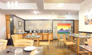 a restaurant with tables and chairs and a painting on the wall at Treebo Trend Edha Suites Koramangala in Bangalore