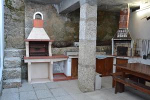 a kitchen with an oven and a wooden table at Casa da Ponte do Arrocho in Loriga