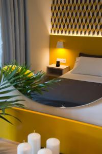 Dormitorio con cama, planta y velas en Sunshine Studios, en Malia