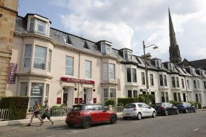 uma rua com carros estacionados em frente aos edifícios em Albion Hotel em Glasgow