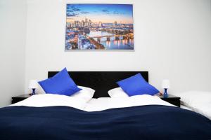 a bedroom with a bed with blue and white pillows at Main Hotel Frankfurt City in Frankfurt/Main