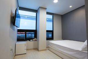 um quarto com uma cama e uma grande janela em O'guest in Haeundae em Busan