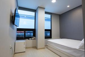 a bedroom with a bed and a large window at O'guest in Haeundae in Busan