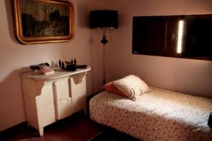 1 dormitorio con cama, tocador y espejo en Casica de Perintín Cottage, en Ricote